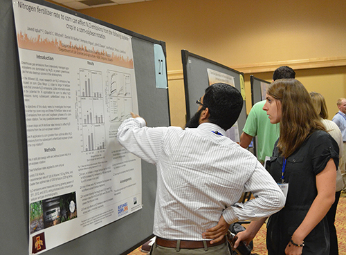 Two People Review a Poster on Nitrogen Fertilizer Rates